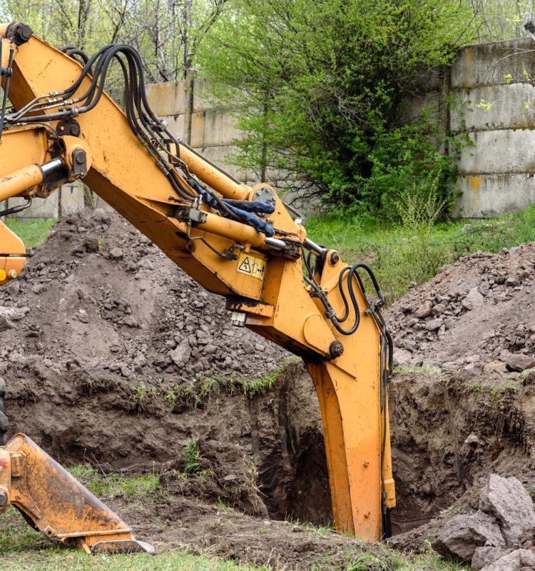 Yellow excavator on a construction site against blue sky. The modern excavator performs excavation work on the construction site